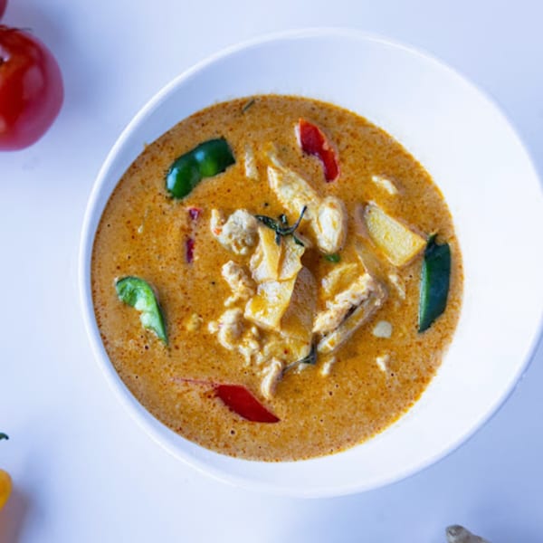 TG Thai Food's red curry with chicken, bamboo shoots, and peppers in a white bowl.