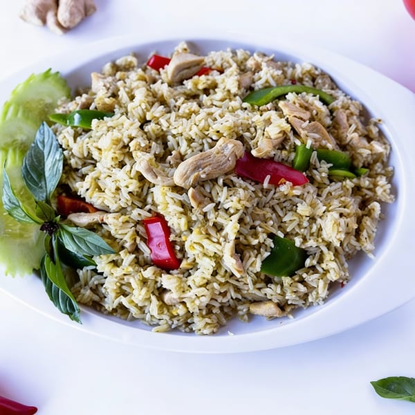 TG Thai Food's green curry fried rice with chicken, red peppers, and basil on a white plate.