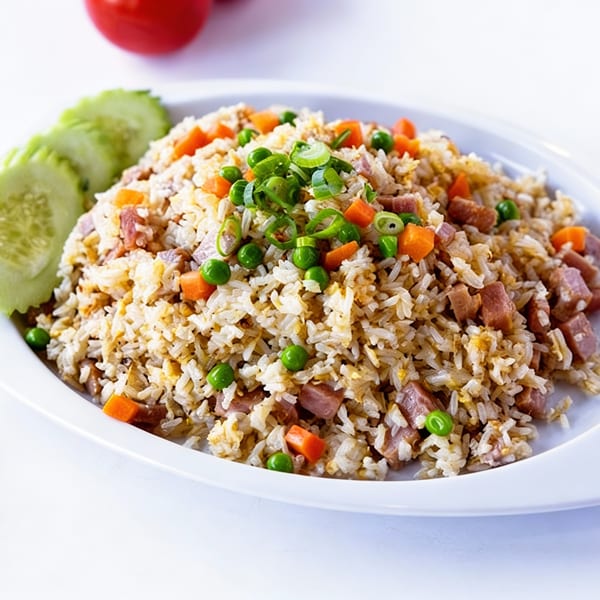 TG Thai Food's fried rice with ham, peas, carrots, and green onions, garnished with cucumber slices.